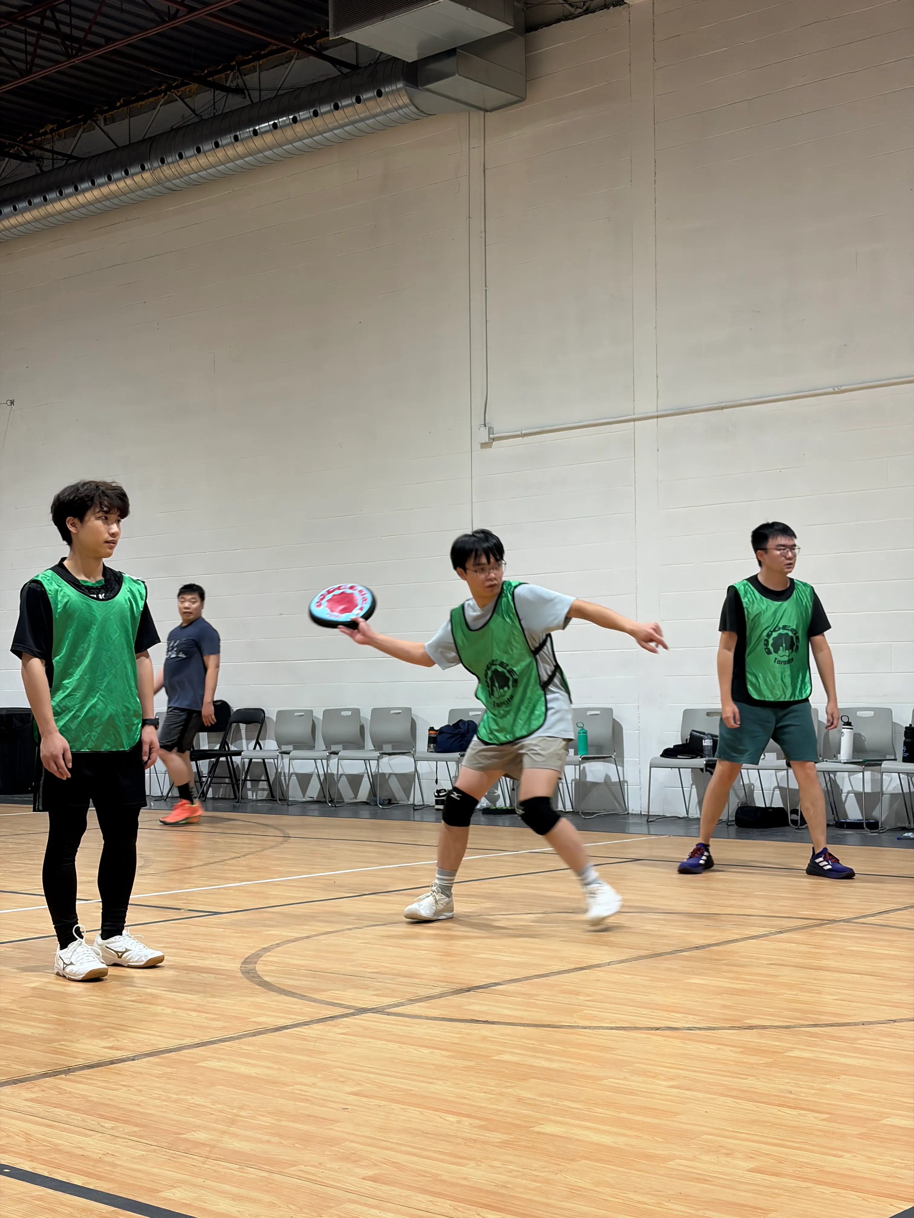 A Toronto Dodgebee player prepares to throw while teammates watch on an indoor court.
